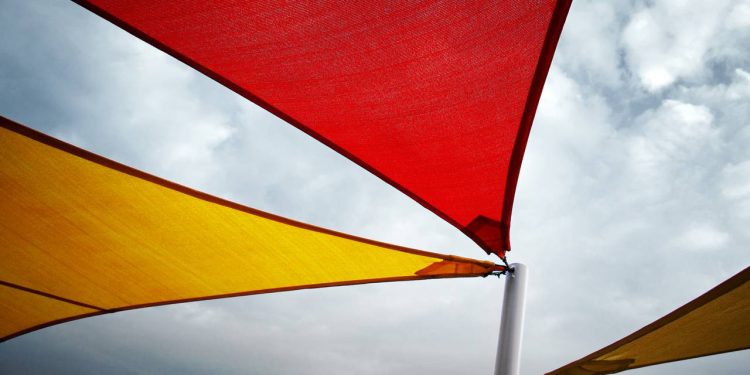 As velas de sombra que se destacam na praia pela proteção solar e montagem simples