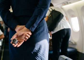 Por que as aeromoças escondem as mãos atrás das costas