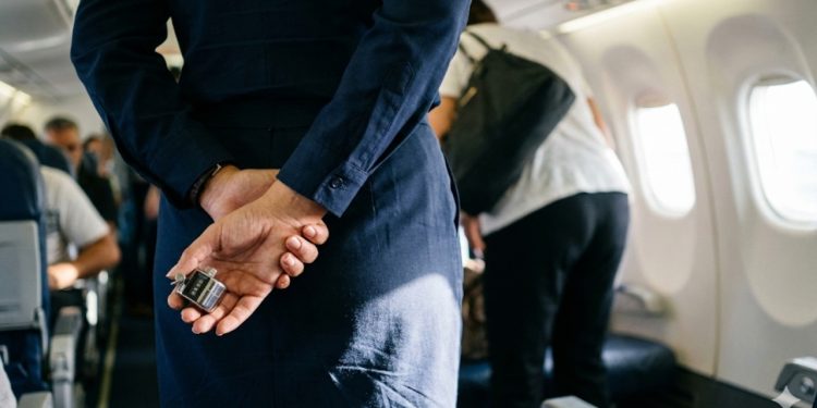 Por que as aeromoças escondem as mãos atrás das costas
