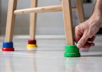Reutilizar tampinhas de garrafa nos pés das cadeiras reduz barulho e protege o piso