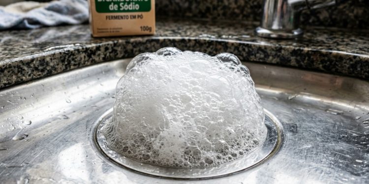 Despeje meio copo de vinagre e bicarbonato de sódio no ralo, e ele se limpará sozinho