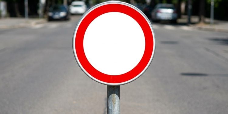 A placa tem nome técnico, R-100, e o primeiro ponto a entender é que ela não existe no Brasil e não tem validade legal em nenhuma via pública brasileira