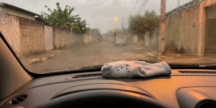 Areia de gato de sílica em meias velhas sobre o painel: absorção passiva de umidade enquanto o carro está parado