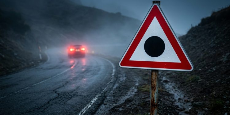 A placa triangular com fundo branco, borda vermelha e um círculo preto no centro parece não dizer nada, mas na prática avisa sobre algo muito específico