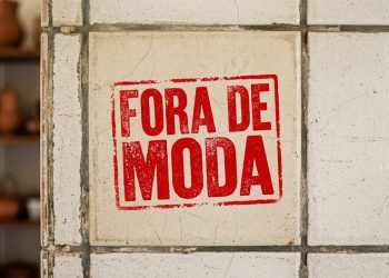 Grupo de arqueólogos examina um canal de água antigo esculpido em pedra, com o monumento de Petra ao fundo entre paredões de arenito.