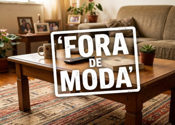 Sala de estar com sofá, mesa de madeira, plantas e carimbo branco escrito “Fora de moda” sobre a imagem.