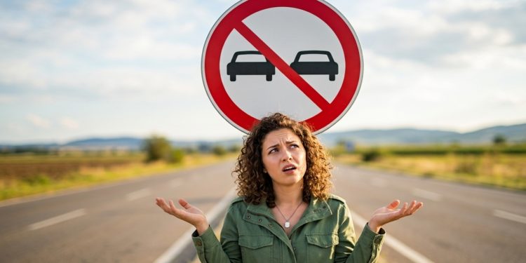 O que significa a placa de trânsito com círculo vermelho e dois carros lado a lado