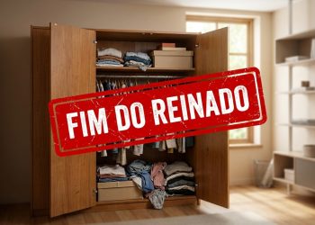 Guarda-roupa antigo de madeira aberto em uma sala, com roupas organizadas e carimbo vermelho escrito “Fim do reinado”.