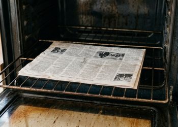 Basta colocar uma folha de jornal dentro do forno e deixá-lo fechado por uma noite para resolver o problema que deixa o cheiro de gordura acumulada