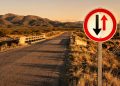 O que significa a placa de trânsito com duas setas opostas, uma preta e uma vermelha?