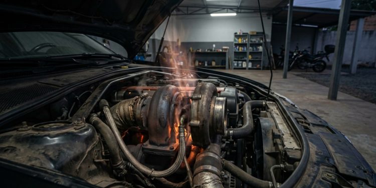 Turbo quente no motor aberto após uso intenso, com mangueiras de óleo, calor visível e risco de borra