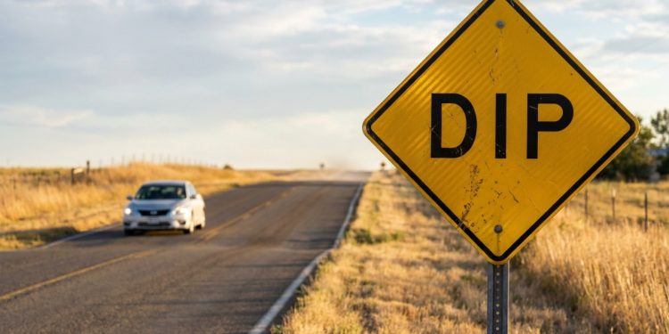 Placa DIP amarela alerta para depressão na pista à frente