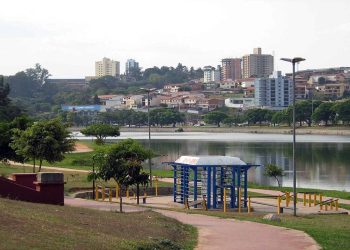 Vista de parque urbano com lago, ciclovia, árvores e prédios ao fundo, em cenário tranquilo de cidade do interior paulista.