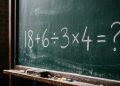 Quadro escolar com a expressão matemática 18 + 6 ÷ 3 x 4 = ? escrita em giz branco.