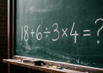 Quadro escolar com a expressão matemática 18 + 6 ÷ 3 x 4 = ? escrita em giz branco.