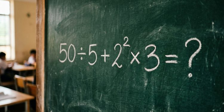Quadro verde em sala de aula com a expressão matemática 50 ÷ 5 + 2² × 3 = ? escrita em giz branco.