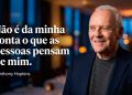 Homem sorridente em ambiente interno elegante aparece ao lado de uma frase em português sobre não se importar com a opinião dos outros.