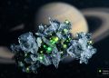 Ilustração macro de grãos de gelo flutuando no espaço sideral com pontos verdes brilhantes indicando a presença de fósforo. Ao fundo, o planeta Saturno aparece levemente desfocado. No canto inferior direito, uma pequena caixa de texto diz: 'Fósforo detectado no oceano de Encélado'.
