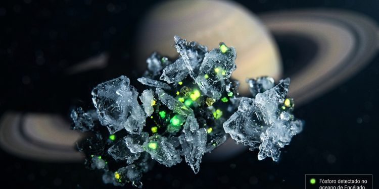 Ilustração macro de grãos de gelo flutuando no espaço sideral com pontos verdes brilhantes indicando a presença de fósforo. Ao fundo, o planeta Saturno aparece levemente desfocado. No canto inferior direito, uma pequena caixa de texto diz: 'Fósforo detectado no oceano de Encélado'.