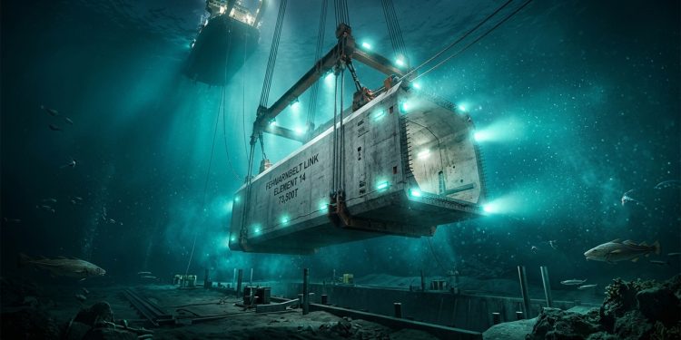 Estrutura de túnel submerso do Fehmarnbelt sendo posicionada no fundo do mar por cabos e embarcação de apoio.