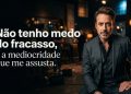 Homem de terno em ambiente escuro aparece ao lado de frase em português sobre medo do fracasso e receio da mediocridade.