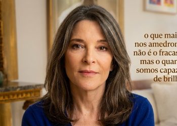 Mulher de meia-idade olha para a câmera em ambiente interno, ao lado da frase “o que mais nos amedronta não é o fracasso, mas o quanto somos capazes de brilhar”.