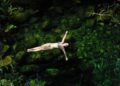 Mulher nadando e relaxando em lagoa no Alto Paraíso do Goiás