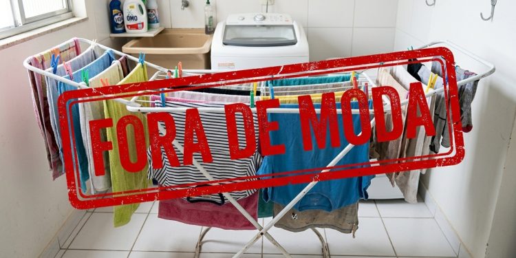 Varal de chão com roupas secando em lavanderia aparece com carimbo vermelho com a frase “Fora de moda”.