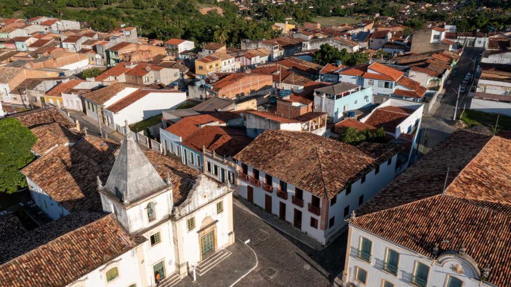 Vista aérea da Praça São Francisco, em São Cristóvão, Sergipe, com igreja histórica, casarões coloniais e telhados de barro.